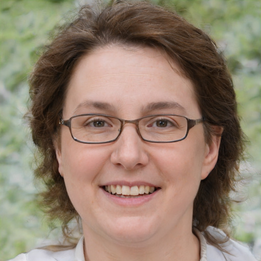 Joyful white adult female with medium  brown hair and green eyes