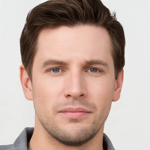 Joyful white young-adult male with short  brown hair and grey eyes