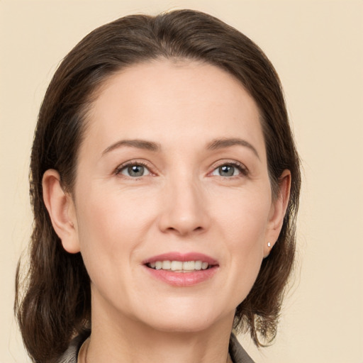 Joyful white young-adult female with medium  brown hair and grey eyes