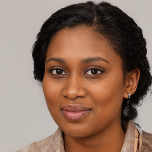 Joyful black young-adult female with long  brown hair and brown eyes