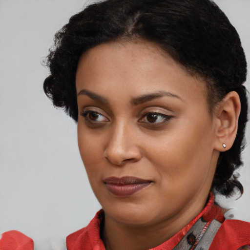 Joyful black young-adult female with short  brown hair and brown eyes