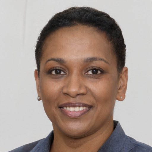 Joyful black young-adult female with short  brown hair and brown eyes