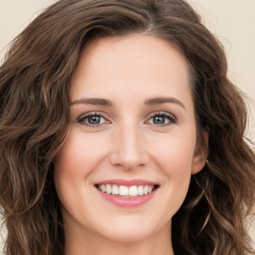 Joyful white young-adult female with long  brown hair and green eyes