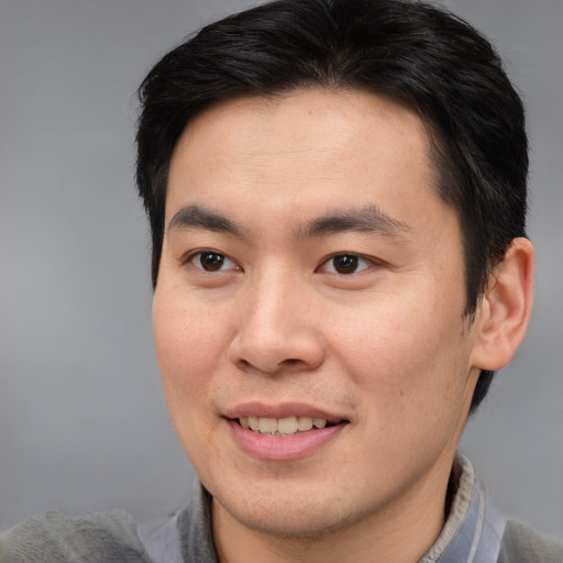 Joyful asian young-adult male with short  brown hair and brown eyes