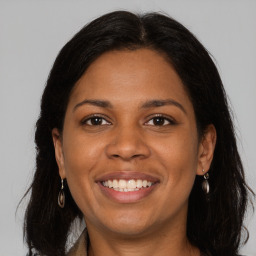 Joyful black young-adult female with long  brown hair and brown eyes