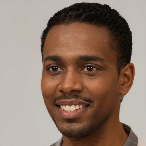 Joyful black young-adult male with short  black hair and brown eyes