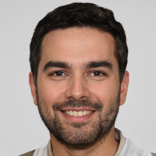 Joyful white young-adult male with short  black hair and brown eyes