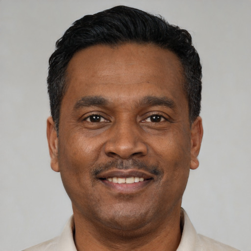 Joyful latino adult male with short  black hair and brown eyes