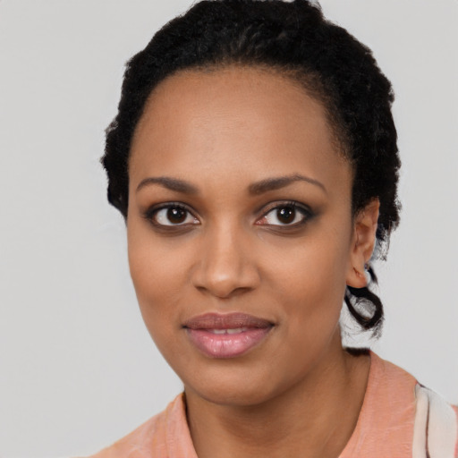 Joyful black young-adult female with short  black hair and brown eyes
