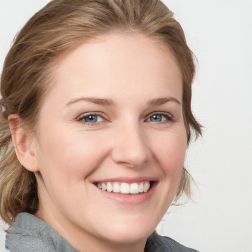 Joyful white young-adult female with medium  brown hair and blue eyes