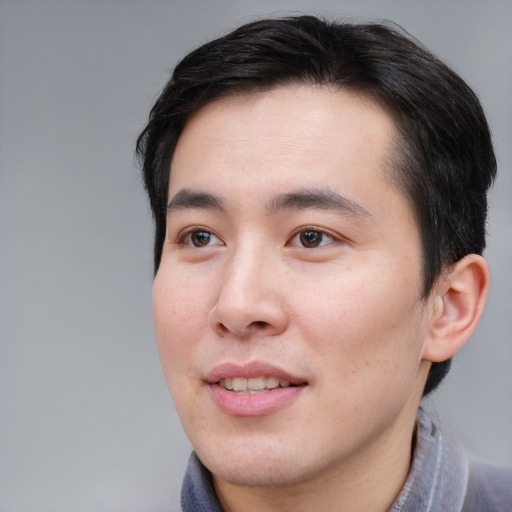 Joyful asian young-adult male with short  brown hair and brown eyes