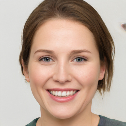 Joyful white young-adult female with medium  brown hair and green eyes