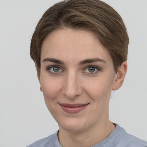 Joyful white young-adult female with short  brown hair and grey eyes