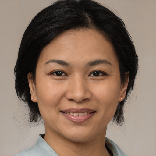 Joyful asian adult female with medium  brown hair and brown eyes