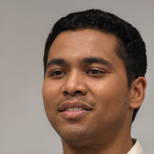 Joyful latino young-adult male with short  black hair and brown eyes