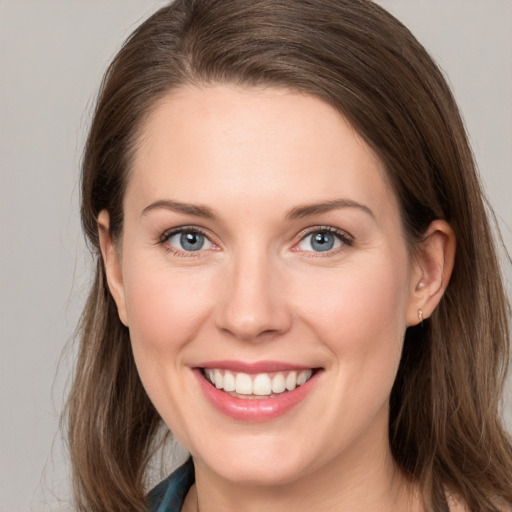 Joyful white young-adult female with long  brown hair and grey eyes