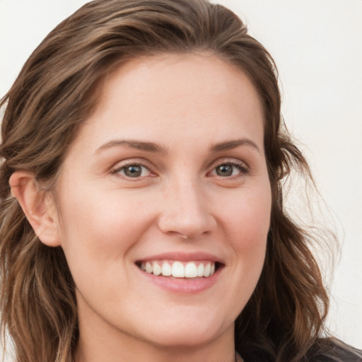 Joyful white young-adult female with long  brown hair and blue eyes