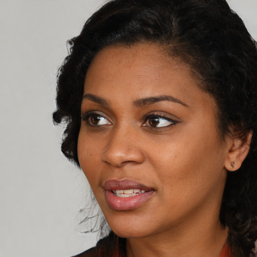 Joyful black young-adult female with medium  black hair and brown eyes