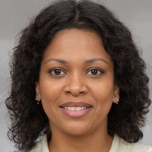 Joyful black young-adult female with medium  brown hair and brown eyes