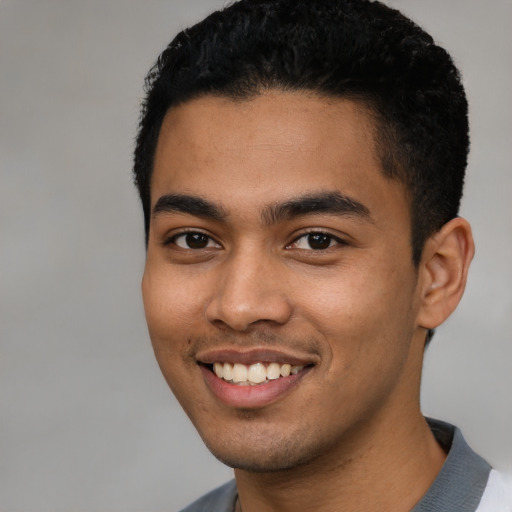 Joyful latino young-adult male with short  black hair and brown eyes