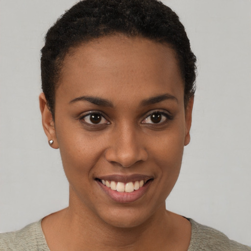 Joyful black young-adult female with short  brown hair and brown eyes