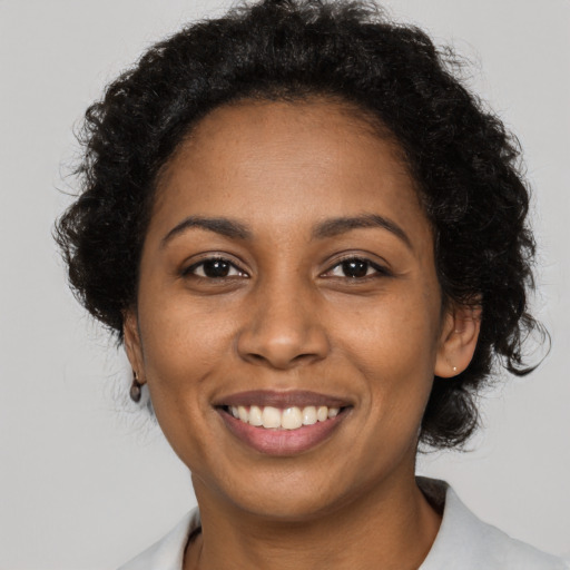 Joyful black young-adult female with medium  black hair and brown eyes