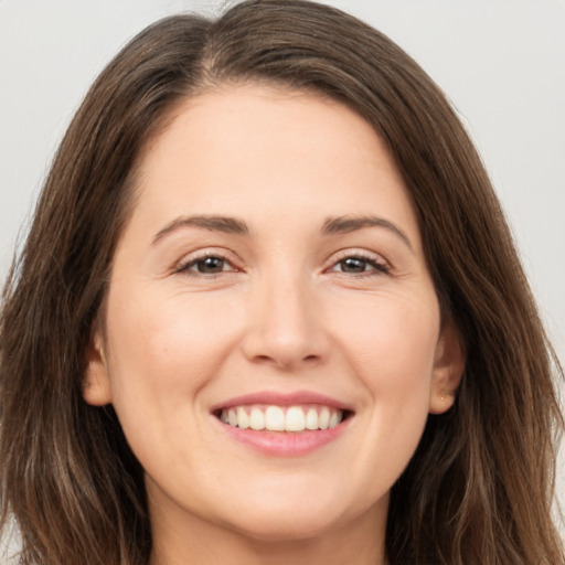 Joyful white young-adult female with long  brown hair and brown eyes