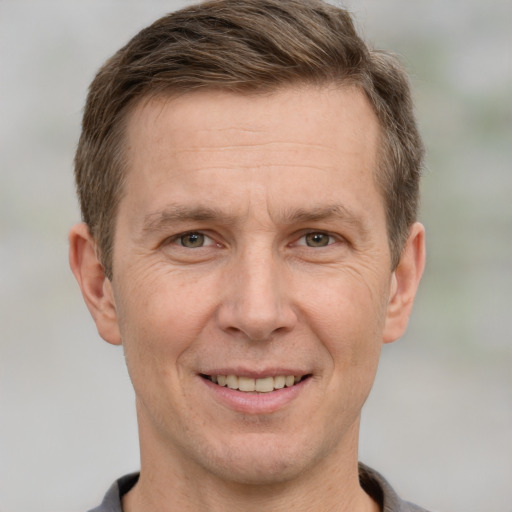 Joyful white adult male with short  brown hair and grey eyes