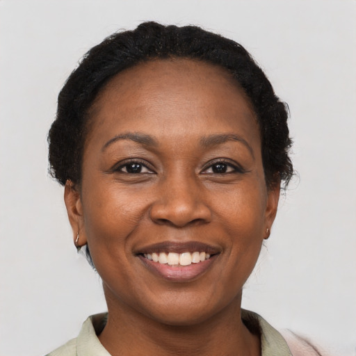 Joyful black adult female with short  brown hair and brown eyes