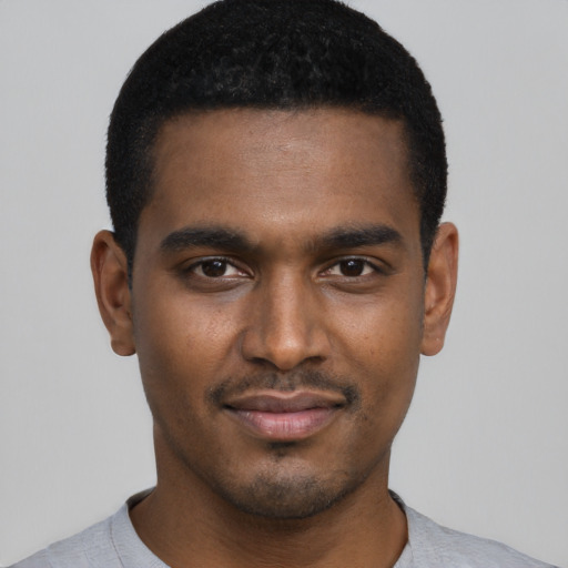 Joyful black young-adult male with short  black hair and brown eyes