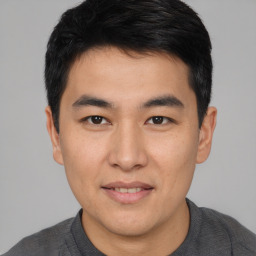 Joyful asian young-adult male with short  brown hair and brown eyes