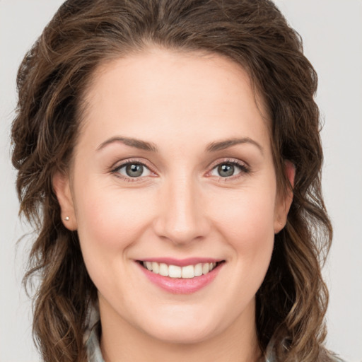 Joyful white young-adult female with long  brown hair and green eyes