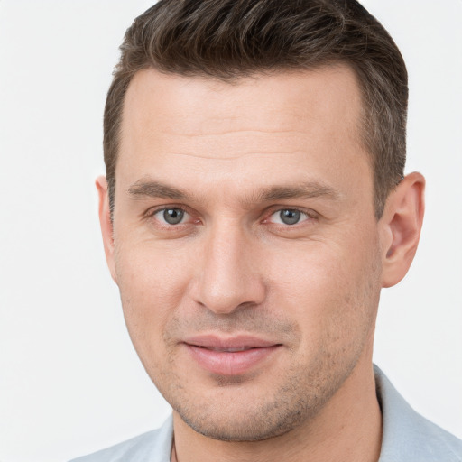 Joyful white young-adult male with short  brown hair and grey eyes