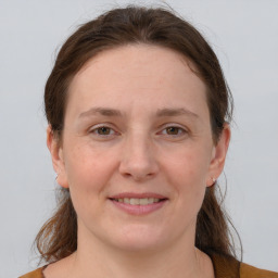 Joyful white young-adult female with medium  brown hair and grey eyes