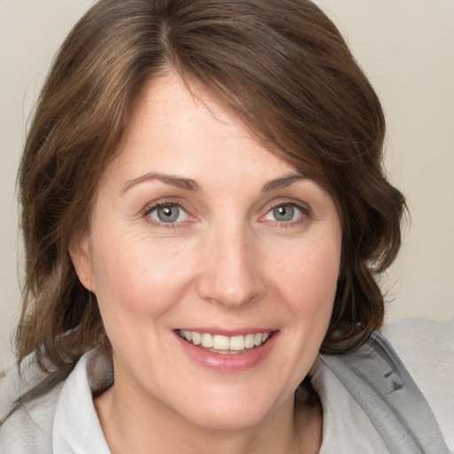 Joyful white young-adult female with medium  brown hair and blue eyes