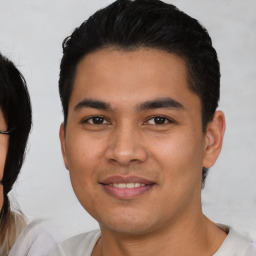 Joyful latino young-adult male with short  black hair and brown eyes