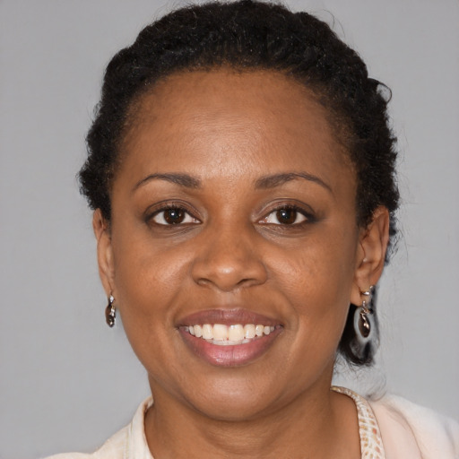 Joyful black adult female with short  brown hair and brown eyes