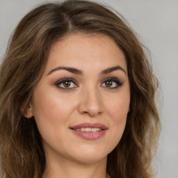 Joyful white young-adult female with long  brown hair and green eyes