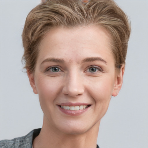 Joyful white young-adult female with short  brown hair and grey eyes