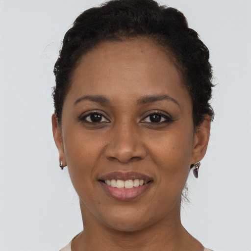 Joyful black young-adult female with short  black hair and brown eyes