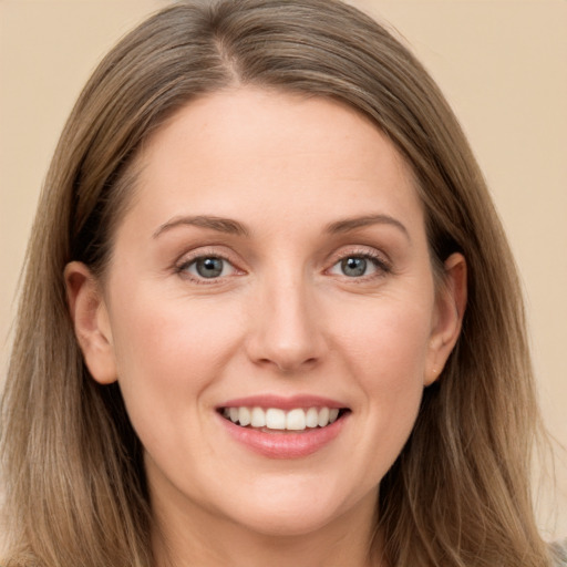 Joyful white young-adult female with long  brown hair and grey eyes