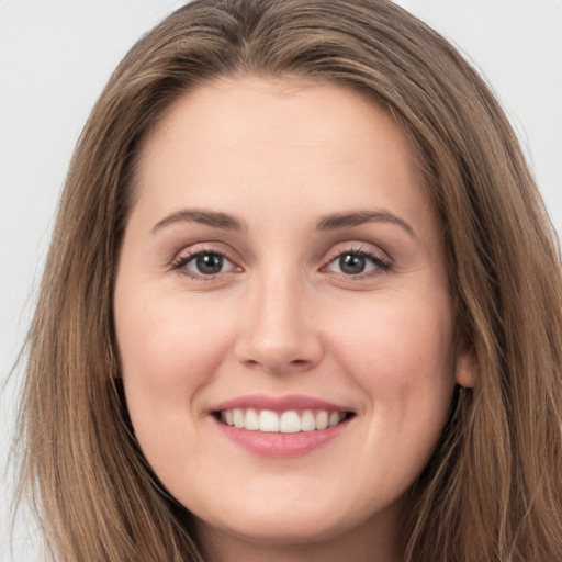 Joyful white young-adult female with long  brown hair and brown eyes