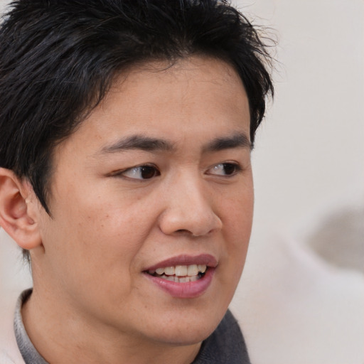 Joyful asian young-adult male with short  brown hair and brown eyes