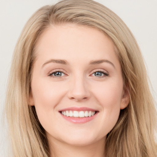 Joyful white young-adult female with long  brown hair and blue eyes