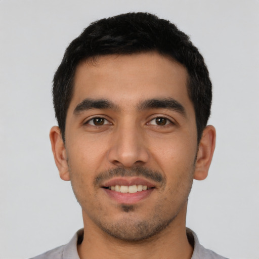 Joyful latino young-adult male with short  black hair and brown eyes