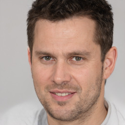 Joyful white adult male with short  brown hair and brown eyes