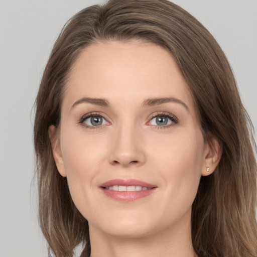 Joyful white young-adult female with long  brown hair and grey eyes