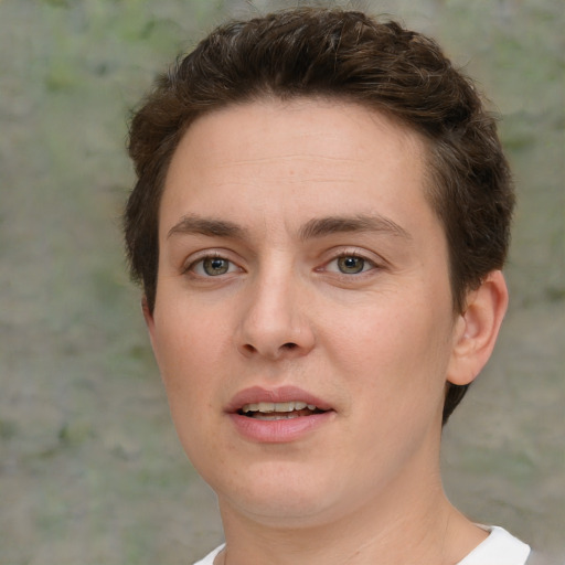 Joyful white young-adult female with short  brown hair and green eyes