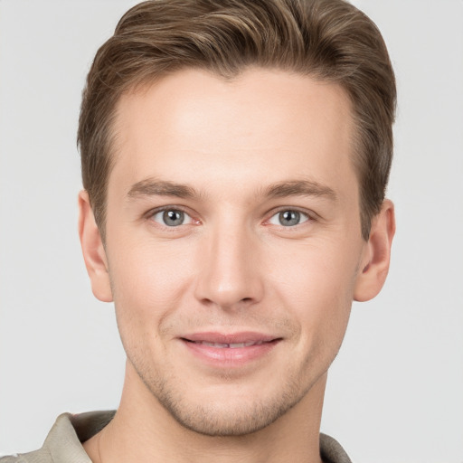 Joyful white young-adult male with short  brown hair and grey eyes