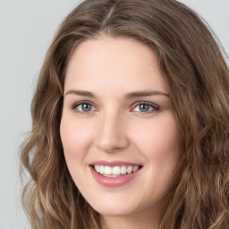 Joyful white young-adult female with long  brown hair and green eyes